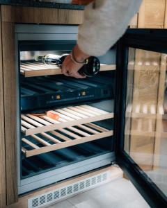 a person is reaching inside of an open refrigerator at Sissi green Chalets in Seefeld in Tirol +80 photos