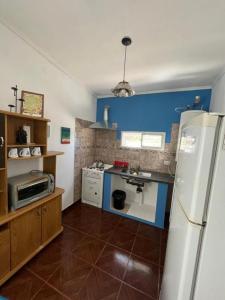a kitchen with a white refrigerator and blue walls at Finca Don Juan Piedra Alta in Junín +14 photos