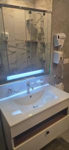 a bathroom with a white sink and a mirror at The Zamalek Residence in Banī Ghālib