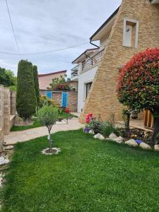 a house with a green yard with flowers and plants at Casa Maia in Eforie Sud