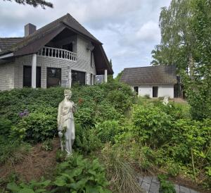 a statue in a garden in front of a house at Fischstuebchen Neeberg in Krummin