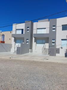 a large white building with stairs in front of it at Departamentos Rada in Rada Tilly