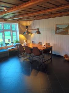 a dining room with a wooden table and chairs at Presterudveien 125 in Vikersund