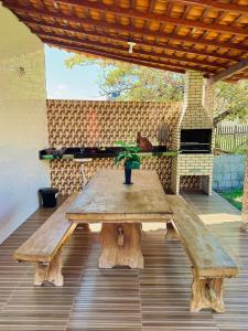 a wooden picnic table with a potted plant on a patio at Casa de Temporada D'Amaro in Santo Amaro +30 photos