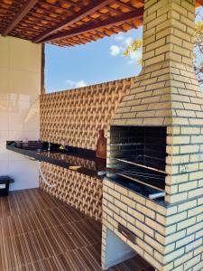 an outdoor brick oven with a wooden deck at Casa de Temporada D'Amaro in Santo Amaro