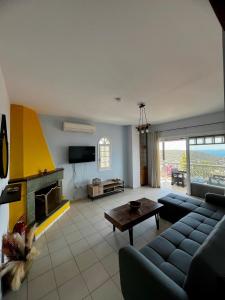 a living room with a couch and a fireplace at Eleni's Seaview House in Saronida
