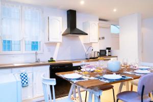 a kitchen with a wooden table and white cabinets at Maison urbaine familiale in Béziers +16 photos