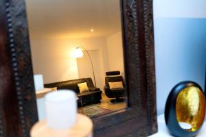 a mirror with a couch in a living room at Maison urbaine familiale in Béziers