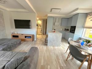 a room with a bed and a kitchen with a table at Family Nest in Ventspils