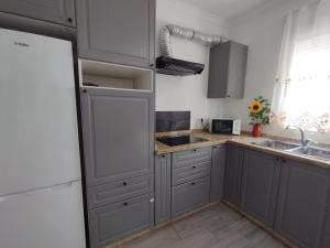 a kitchen with gray cabinets and a sink and a window at La Cumbre in Algodonales
