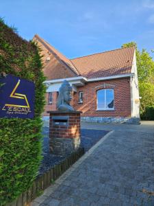 a statue in front of a house with a building at L Escale Spa Privatif in Tournai