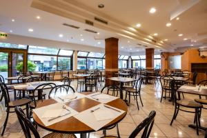 an empty dining room with tables and chairs at Hotel Paola Garden in Rimini