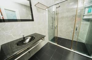 een badkamer met een wastafel en een glazen douche bij Sunflower Guesthouse in Karon Beach