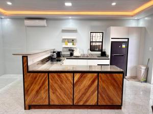a kitchen with a wooden island in the middle at Cozy Manor with Spacious Kitchen and Tub in General Santos