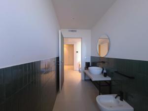 a bathroom with a sink and a toilet and a mirror at Emme Urban Suites in Polignano a Mare +54 photos