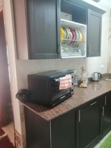 eine Mikrowelle auf einer Küchentheke in der Unterkunft شاليه محجوب بديمورا in Dawwār Muḩammad Abū Shunaynah