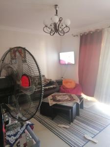 ein Wohnzimmer mit Ventilator und Couch in der Unterkunft شاليه محجوب بديمورا in Dawwār Muḩammad Abū Shunaynah