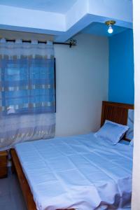 Ένα ή περισσότερα κρεβάτια σε δωμάτιο στο Chambre privée dans appart à Bafoussam Diengdam proche agence BlueBird