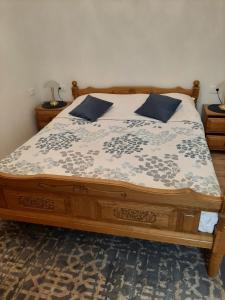 a bedroom with a wooden bed with blue pillows at Apartmani Banina in Ika