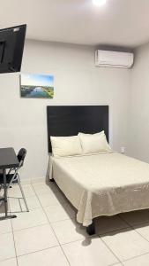 a bedroom with a bed and a desk and a television at HOTEL TAMPICO EXPRESS MORALILLO in Tampico