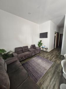 a living room with a couch and a tv at Cozy haven apartments in Paramaribo