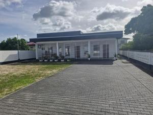 a house with a brick driveway in front of it at Cozy haven apartments in Paramaribo