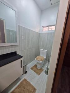 a bathroom with a toilet and a sink and a mirror at Cozy haven apartments in Paramaribo +8 photos