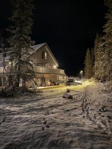 a house on a snow covered street at night at Fjällbäcken Lindvallen Sälen in Sälen