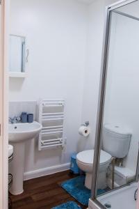a white bathroom with a toilet and a sink at Monea Retreat a Modern 2bedroom and 2 bathroom apartment in Coventry in Coventry
