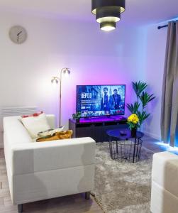 a living room with a white couch and a tv at Monea Retreat a Modern 2bedroom and 2 bathroom apartment in Coventry in Coventry