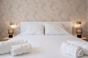 a bedroom with a white bed with towels on it at Palmera del mar in Alicante
