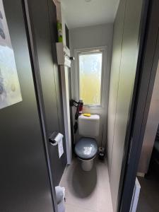 a small bathroom with a toilet and a window at Bungalow in Gassin