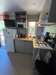 a kitchen with a stove and a white refrigerator at Bungalow in Gassin +3 photos