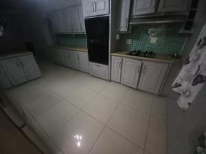 een keuken met witte kasten boven het plafond bij Versailles B and B in Gonubie