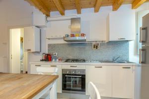 a kitchen with white cabinets and a wooden table at Atena at Como Duomo in Como