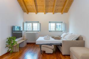 a room with a bed and a couch and windows at Atena at Como Duomo in Como
