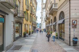 people walking down a street in a city with buildings at Atena at Como Duomo in Como