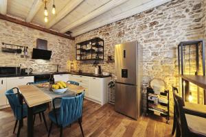 a kitchen with a table and a stainless steel refrigerator at Vacation House Meri in Blato