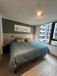 a bedroom with a bed and a large window at Deptos Boutique en pleno centro de Santiago in Santiago +53 photos