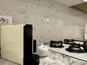 a kitchen counter with a stove and a microwave at Palazzo Palloni Boutique Apartment in Sorano