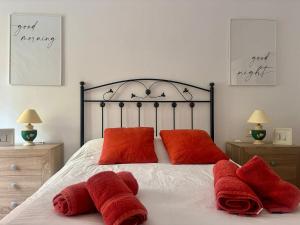 ein Schlafzimmer mit einem Bett mit roten Handtüchern darauf in der Unterkunft Piso en el precioso pueblo de Colunga in Colunga