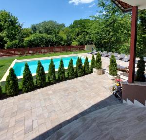 a swimming pool with a row of trees next to it at Pink Elephant in Subotica