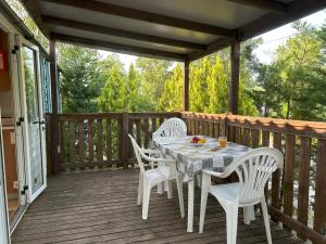 a table and chairs on a wooden deck at AdriaCamp Mobile Homes Rosapineta in Rosapineta