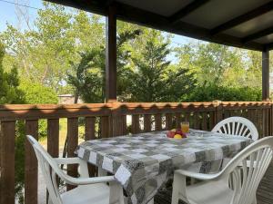 a table and chairs on a wooden deck at AdriaCamp Mobile Homes Rosapineta in Rosapineta