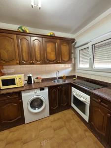 eine Küche mit Waschmaschine und Mikrowelle in der Unterkunft Piso en el precioso pueblo de Colunga in Colunga + 9 Fotos