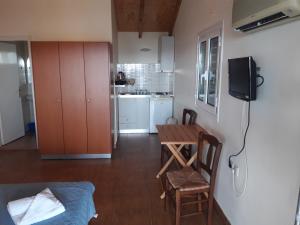 a living room with a table and a small kitchen at olivensun studio 11 in Gythio