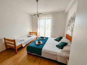 a bedroom with two beds with green pillows at apartman MLIN 4 in Lun
