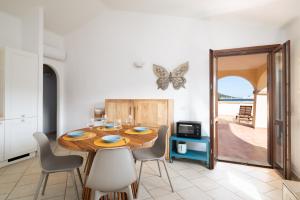 a dining room with a table and chairs and a butterfly on the wall at Villaggio Perlacea - Your House in Sardinia in Golfo Aranci +67 photos