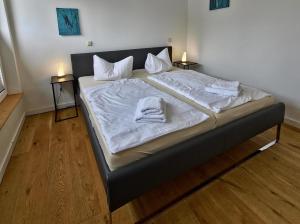 a large bed with white sheets and towels on it at Fischstübchen Neeberg Fewo 4 – Schwalbennest in Krummin