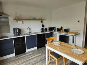 a kitchen with a wooden table and a wooden table and chairs at River View in Kilcar